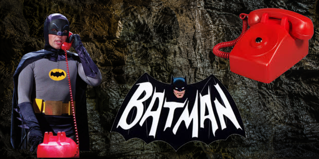 Batman-thema afbeelding met rode Bat-Phone, Batman-logo en een grotachtige achtergrond als inspiratie voor de EventTelefoon Hot-Line.