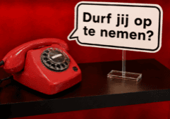 Rode retro EventTelefoon met draaischijf en een spraakballon met de tekst ‘Durf jij op te nemen?’, geplaatst op een transparante plexiglas standaard.